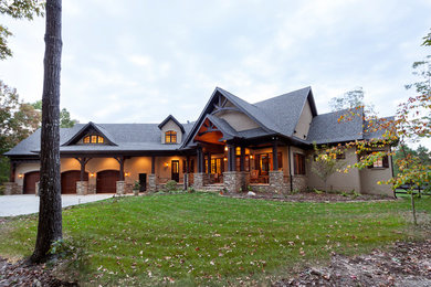 Example of a large mountain style gray two-story stucco exterior home design in Charlotte with a shingle roof