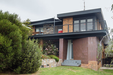 Modelo de fachada gris minimalista de dos plantas con revestimiento de metal y tejado plano