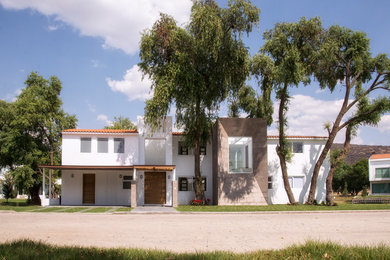 Modelo de fachada de casa blanca contemporánea grande de dos plantas con revestimiento de piedra y tejado de teja de barro