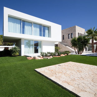Idee per la facciata di una casa ampia bianca tropicale a piani sfalsati con rivestimenti misti e tetto piano