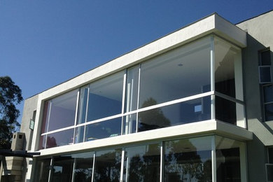 Imagen de fachada blanca moderna de tamaño medio de dos plantas con revestimiento de hormigón