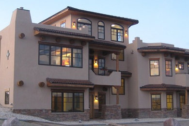 Modelo de fachada beige de estilo americano grande de tres plantas con revestimiento de estuco y tejado plano