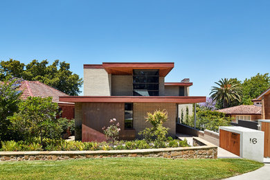 Inspiration för ett mellanstort funkis grått hus, med tre eller fler plan, tegel, platt tak och tak i metall