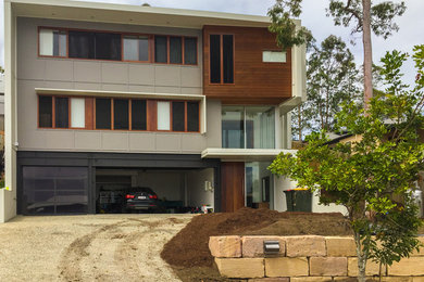 Modelo de fachada minimalista grande a niveles con revestimiento de aglomerado de cemento