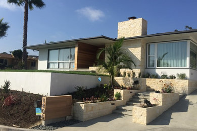 Inspiration for a large 1960s beige one-story stone flat roof remodel in Orange County
