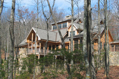 Diseño de fachada marrón rústica grande de tres plantas con revestimiento de madera y tejado a dos aguas