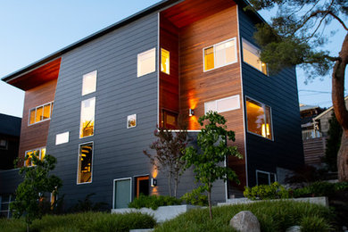 Пример оригинального дизайна: трехэтажный, деревянный, разноцветный частный загородный дом среднего размера в стиле модернизм с плоской крышей