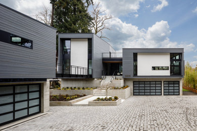 На фото: большой, двухэтажный, серый частный загородный дом в стиле ретро с плоской крышей с
