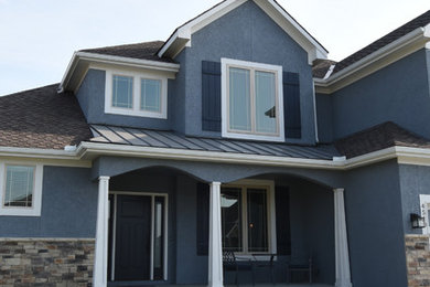 Inspiration for a large transitional blue two-story stucco house exterior remodel in Kansas City with a shingle roof