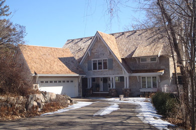 Imagen de fachada de casa beige clásica grande de dos plantas con revestimiento de madera, tejado a dos aguas y tejado de teja de madera