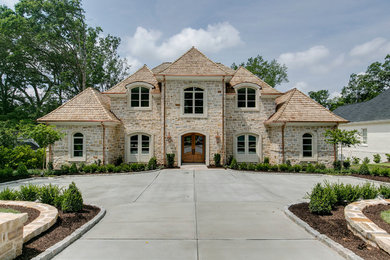 Elegant beige two-story stone house exterior photo in Raleigh with a hip roof and a shingle roof
