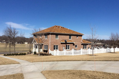 This is an example of a medium sized and brown two floor brick house exterior in Minneapolis with a hip roof.