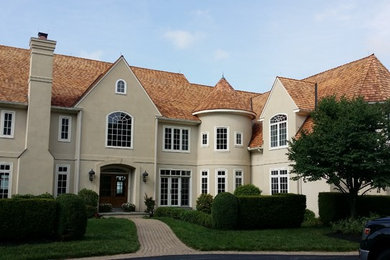 Inspiration for a large timeless beige two-story stucco exterior home remodel in Philadelphia with a hip roof