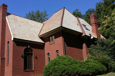 Example of a huge classic red two-story brick exterior home design in Philadelphia with a hip roof