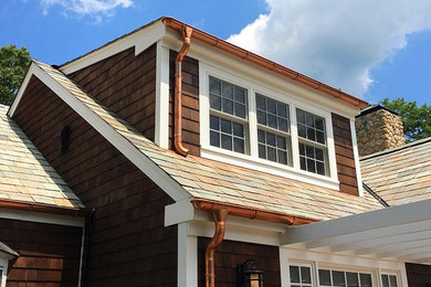 Imagen de fachada de casa marrón campestre de tamaño medio de dos plantas con revestimiento de madera, tejado a dos aguas y tejado de teja de madera