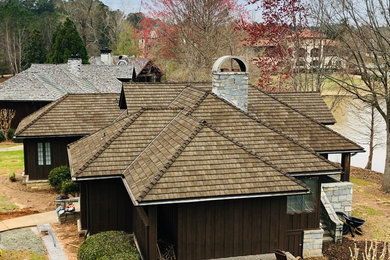 Ejemplo de fachada de casa marrón de estilo americano de tamaño medio de una planta con revestimiento de madera, tejado a cuatro aguas y tejado de varios materiales