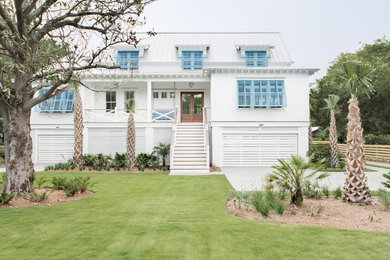 White nautical detached house in Charleston with a hip roof and a metal roof.