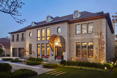 Transitional beige two-story stone exterior home idea in Chicago with a hip roof