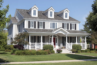 Modelo de fachada de casa gris clásica renovada grande de dos plantas con revestimiento de vinilo, tejado a dos aguas y tejado de teja de madera