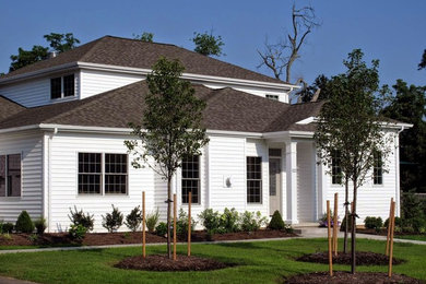 Foto de fachada blanca tradicional de tamaño medio de dos plantas con revestimiento de vinilo y tejado a la holandesa