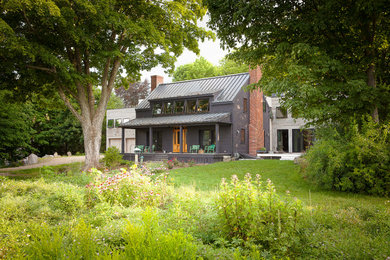 Modelo de fachada de casa gris de estilo de casa de campo de dos plantas con revestimiento de madera y tejado de metal