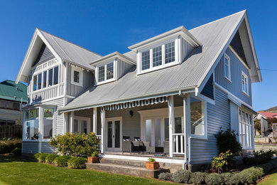 Diseño de fachada de casa gris clásica de dos plantas con tejado a dos aguas y tejado de metal