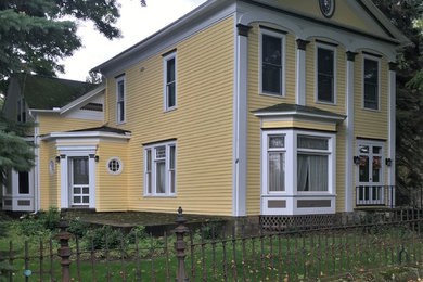 Example of a large classic yellow two-story concrete fiberboard gable roof design in New York