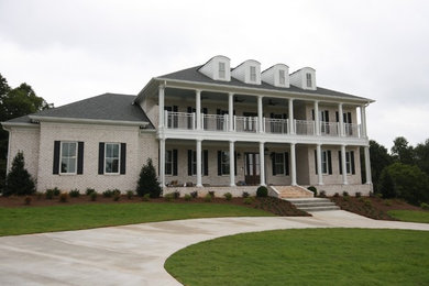 Example of a classic white three-story brick house exterior design in Atlanta with a hip roof and a shingle roof