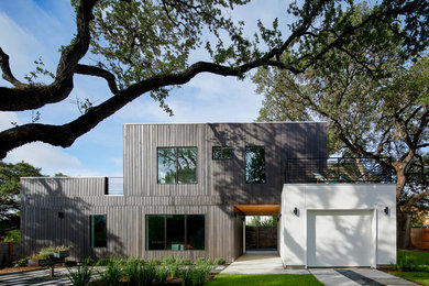 Idée de décoration pour une petite façade de maison noire design en bois à un étage avec un toit plat.