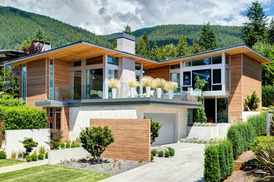 Example of a trendy two-story wood exterior home design in Vancouver with a shed roof