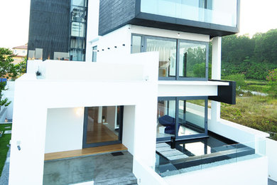 Imagen de fachada de casa blanca minimalista grande de tres plantas con revestimiento de hormigón, tejado plano y tejado de varios materiales