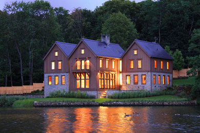Imagen de fachada marrón tradicional grande de tres plantas con revestimiento de madera y tejado a dos aguas