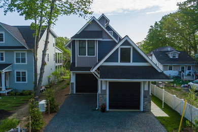 Foto de fachada de casa azul de estilo americano de tamaño medio de tres plantas con revestimiento de vinilo y tejado de teja de madera