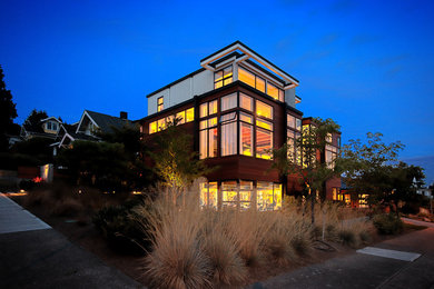 Photo of an expansive and brown modern detached house in Seattle with wood cladding, three floors, a flat roof and a metal roof.