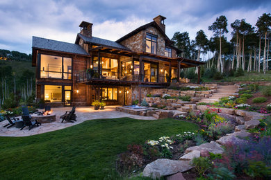 Inspiration for a large transitional brown three-story stone gable roof remodel in Denver