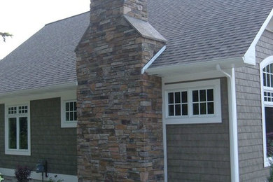 Imagen de fachada de casa gris tradicional de tamaño medio de una planta con revestimiento de madera, tejado a dos aguas y tejado de teja de madera