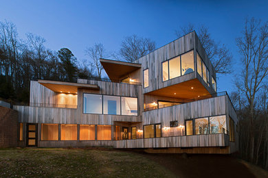 Inspiration för stora moderna beige trähus, med tre eller fler plan och platt tak
