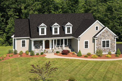 Exemple d'une façade de maison beige nature de taille moyenne et à un étage avec un revêtement mixte et un toit à deux pans.