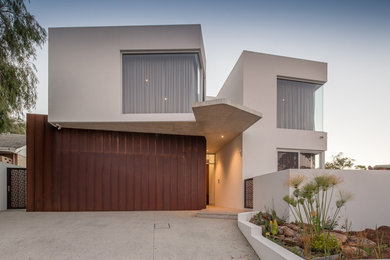 Cette image montre une grande façade de maison métallique et blanche design à un étage avec un toit plat.