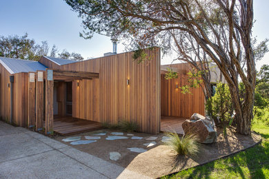 Medium sized contemporary bungalow detached house in Melbourne with wood cladding, a pitched roof and a metal roof.
