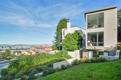 Large minimalist gray three-story stucco exterior home photo in San Francisco