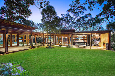 Expansive contemporary two floor house exterior in Sydney with wood cladding and a flat roof.