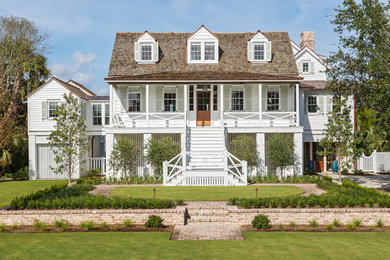 Стильный дизайн: белый, трехэтажный, деревянный частный загородный дом в морском стиле с вальмовой крышей и крышей из гибкой черепицы - последний тренд