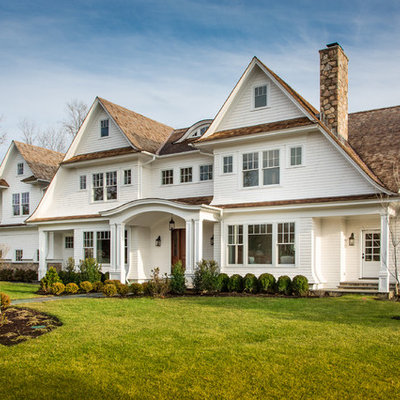 Inspiration for a large timeless white three-story wood exterior home remodel in New York with a shingle roof