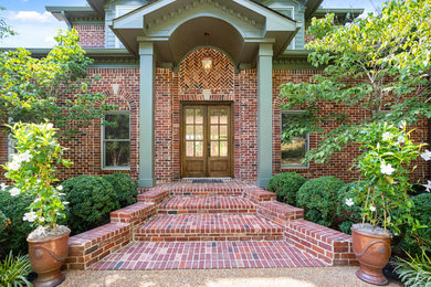 Inspiration for a large timeless two-story brick house exterior remodel in Nashville with a shingle roof