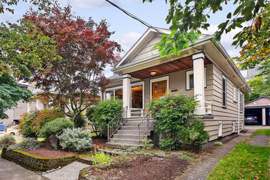 Arts and crafts beige one-story wood house exterior photo in Seattle with a shingle roof and a gray roof