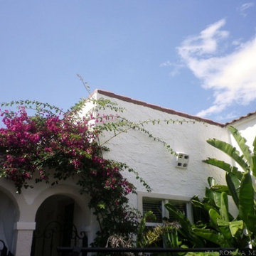 classic white 1920's mediterranean revival home with red barrel tile roof @ skyl