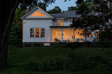 Imagen de fachada de casa blanca campestre de tamaño medio de dos plantas con revestimiento de madera, tejado a dos aguas y tejado de teja de madera