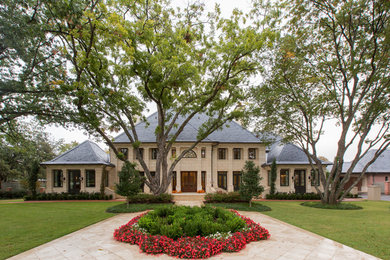 Huge traditional beige two-story stone house exterior idea in Dallas