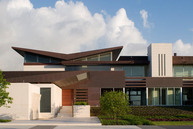 Foto della facciata di una casa contemporanea con rivestimento in pietra e copertura in metallo o lamiera